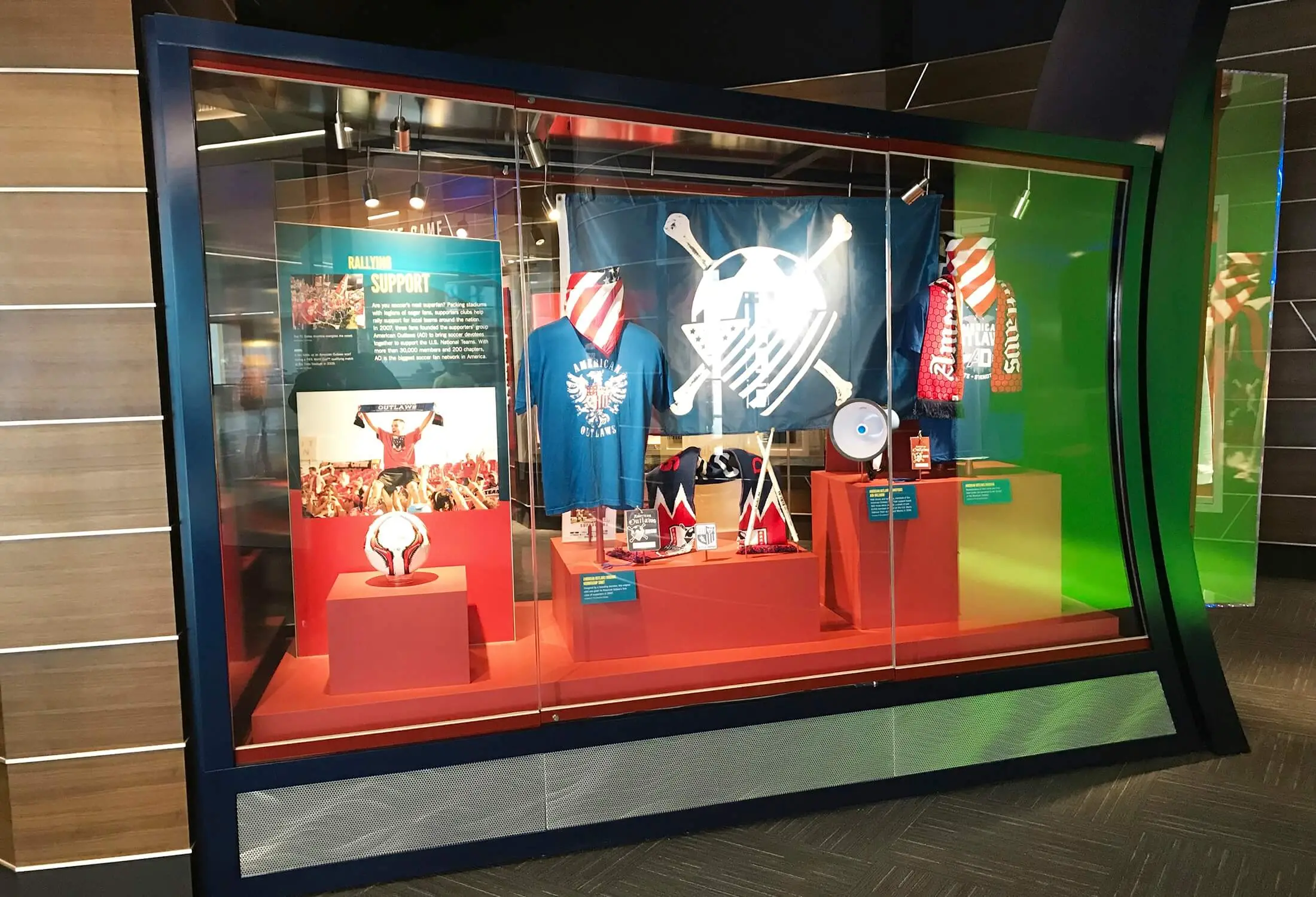 Exhibit case with lit graphics and jerseys