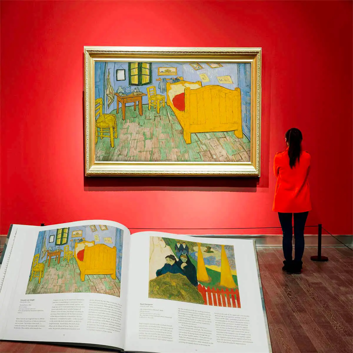 Van Gogh’s Bedroom in Arles on a red gallery wall with the matching book spread